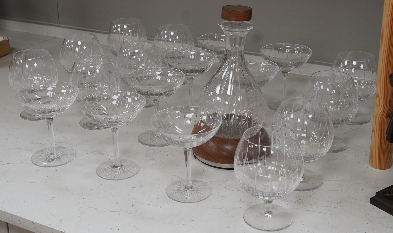 A Linley Glyndebourne pattern cut glass decanter with a silver mounted stopper, on a weighted wooden coaster stand, and a matching set of ten goblets and eight champagne coupes, largest 30cm high. Condition - all in very